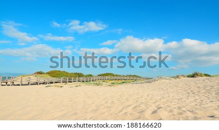 golden sand and wooden hand rail in Platamona beach, Sardinia