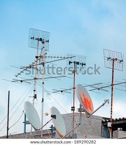 old tv antennas on a building roof