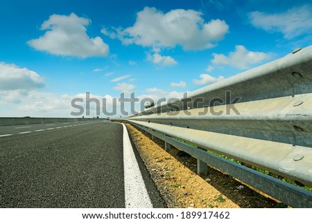metal guard rail under a cloudy sky