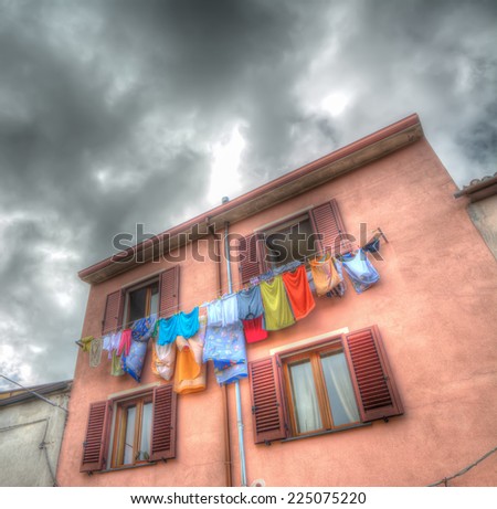 laundry line with clothes in an old building under a cloudy sky. Iso 100, heavy processed for hdr tone mapping