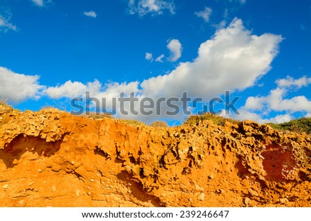 red soil under a blue sky with clouds. Shot in Alghero, Italy