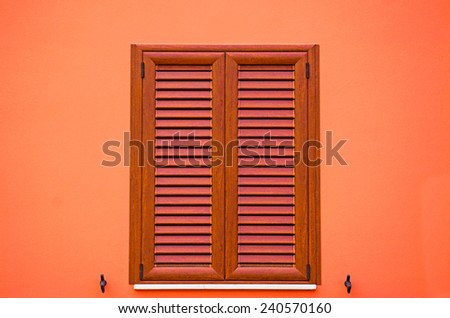 brown shutters in an orange wall