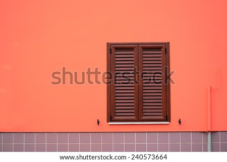 brown window in an orange and gray wall