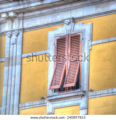 brown shutters in a yellow wall. Processed for hdr tone mapping effect.