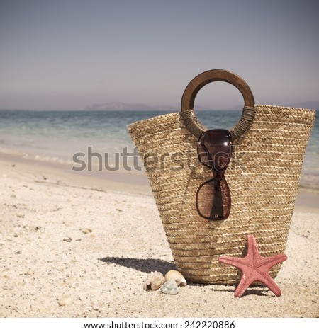 straw bag with sunglasses and starfish in vintage tone