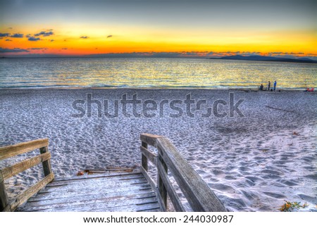 wooden boardwalk by the sea at sunset. Shot in Alghero, Italy