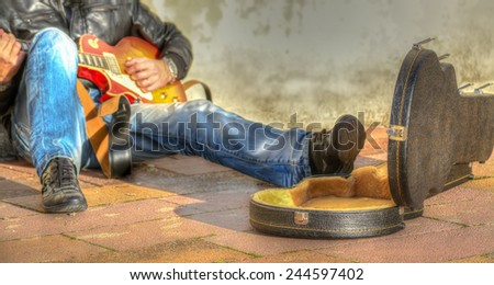 guitar player in the street with an open guitar case