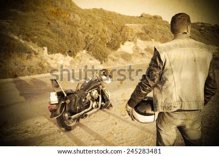 biker with motorcycle on the edge of the road