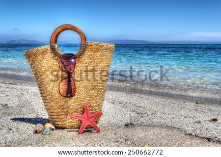 straw bag, starfish and shell by the shore. Processed for hdr tone mapping effect