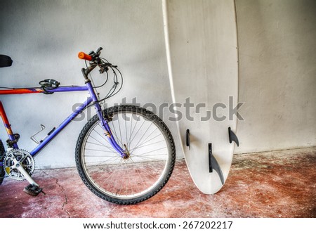 mountain bike and surfboard in a garage in hdr tone mapping effect