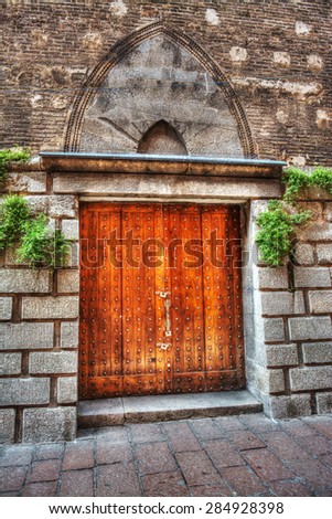 orange door in an old wall in Bologna, Italy