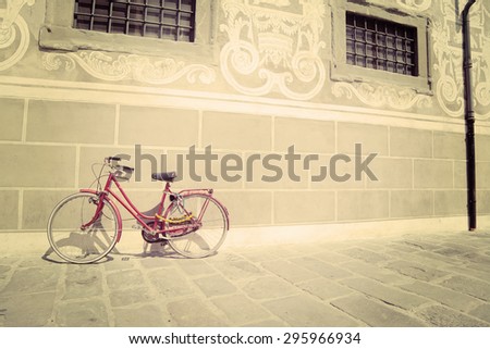 red bike leaning against a wall in vintage tone effect