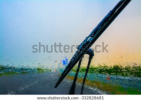 wiper on a wet windshield at sunset