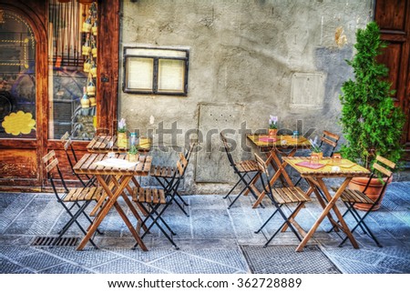 rustic tables and chairs by a trattoria in Florence, Italy