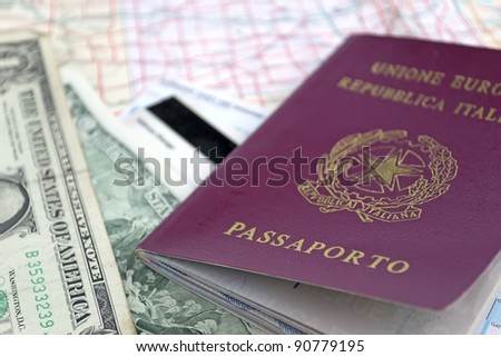 italian passport and us dollars on a road map
