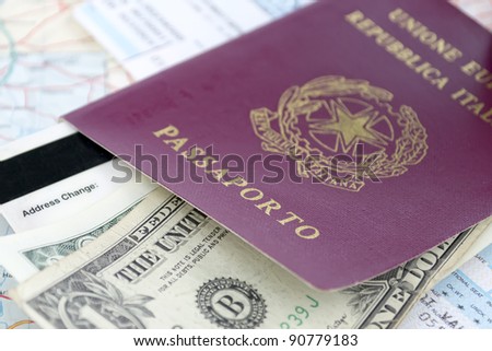 Italian passport, us dollars and airline ticket on a road map