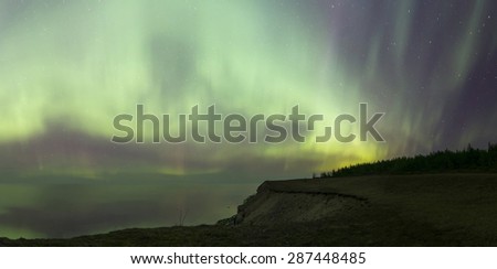Beautiful colorful Northern Lights with water reflections. Panoramic image photographed in Saaremaa Estonia.