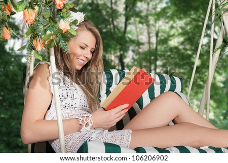 Young blonde woman reading a book resting in lounge