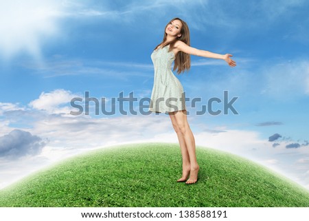Happy young woman standing on abstract small green planet