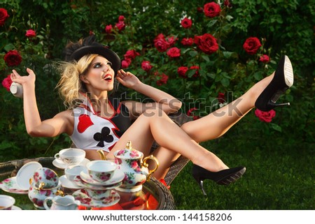 Young woman posing as magnificent card queen from wonderland at mystic tea-party