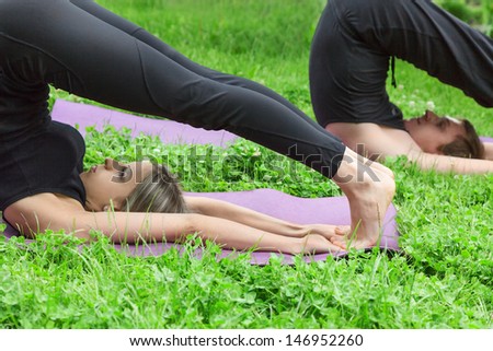 Man and woman doing yoga. Outdoor in a garden