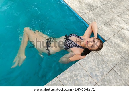 Attractive young woman swimming on a spa\'s pool. Beauty portrait in water