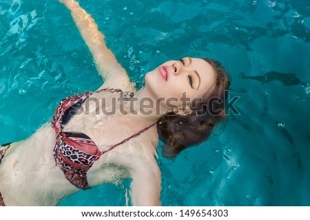 Attractive young woman swimming on a spa\'s pool. Beauty portrait in water