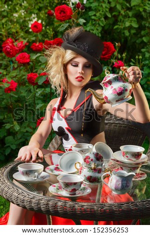 Young woman posing as magnificent card queen from wonderland at mystic tea-party