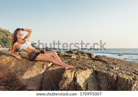 Young woman looking at sea. Sunset time outdoor portrait made in India, State Goa