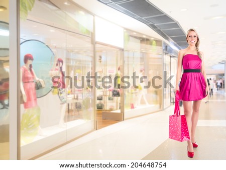 Young beautiful woman in pink mini dress at shopping mall