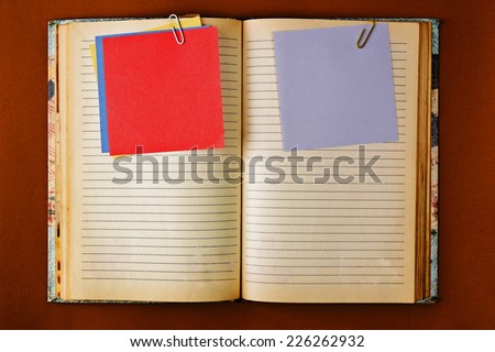 Old notebook with stained pages on brown paper surface. Useful for web site template design