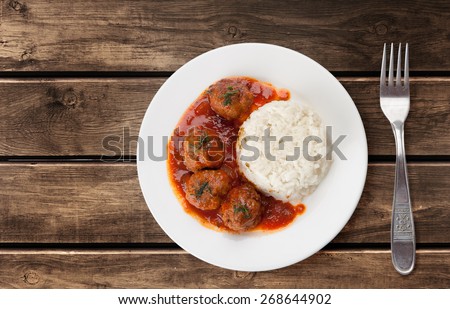 Traditional roasted meatballs with rice and tomato sauce
