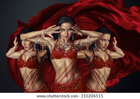 Beautiful belly dancer perfoming exotic dance in red flutter dress