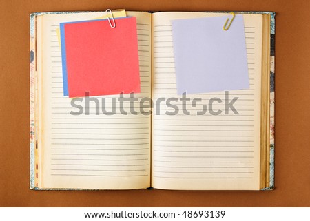 Old notebook with stained pages on brown paper surface. Useful for web site template