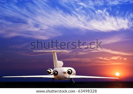 Passenger jet airliner on ground and stunning sunset