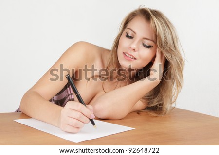 Young woman writing letter on paper sheet
