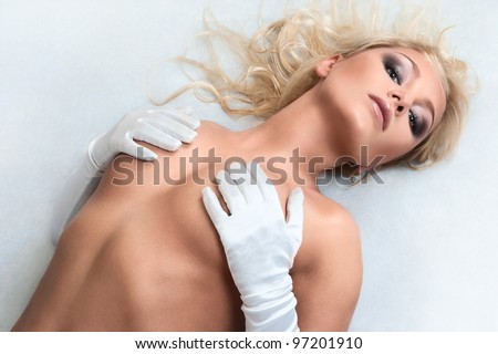 Naked young sexy blonde girl lying down on floor