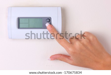 Thermostat. Woman\'S Hand Turn Off The Room Temperature On A Modern Programmable Digital Wall Heater. Closeup