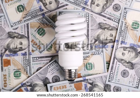 CFL Fluorescent Light Bulb on money dollar cash background