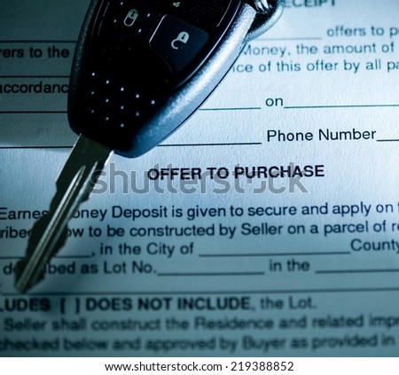 Close up of contract and car key.