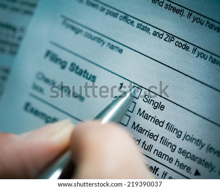 Close up of a hand holding pen and marking check box.