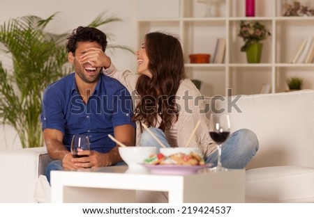 Happy couple eating chinese food and drinking wine at home.