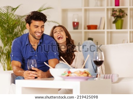 Happy couple eating chinese food and drinking wine at home.