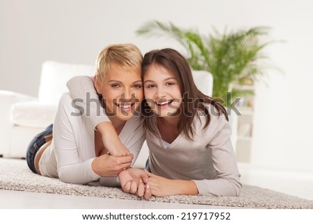 Mother and daughter talking and laughing in their home.