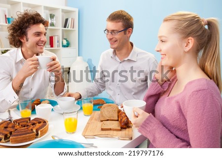 Four friends having breakfast at home.