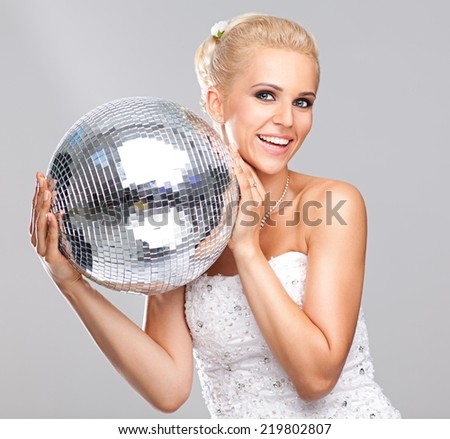 Crazy caucasian bride holding shiny disco ball.