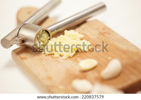 Crushed garlic on a cutting board prepared for cooking.
