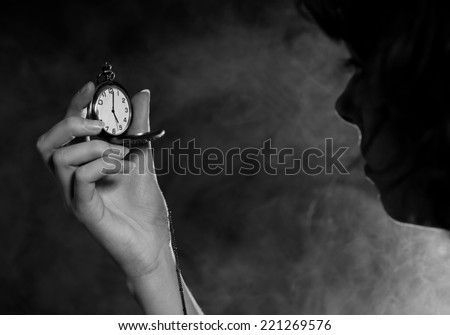 Female holding pocket watch. Backlit. Black and white,.