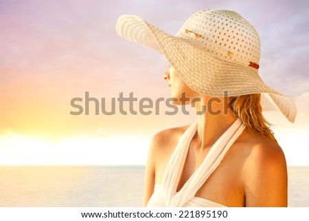 Young woman with a hat enjoying summer at the beach.