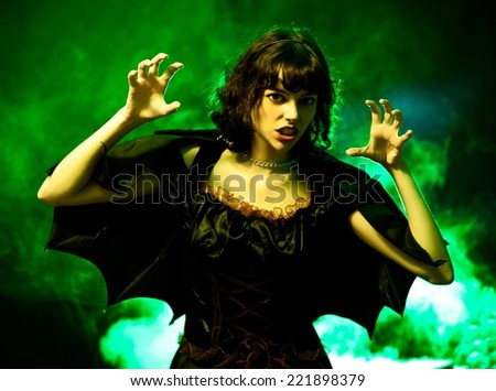 Scary woman in a Halloween costume with bat wings.